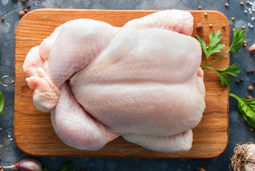 Whole raw chicken on a wooden board with spices for cooking, top view, horizontal, copy space Whole raw chicken on a wooden board with spices for cooking, top view, horizontal, copy space